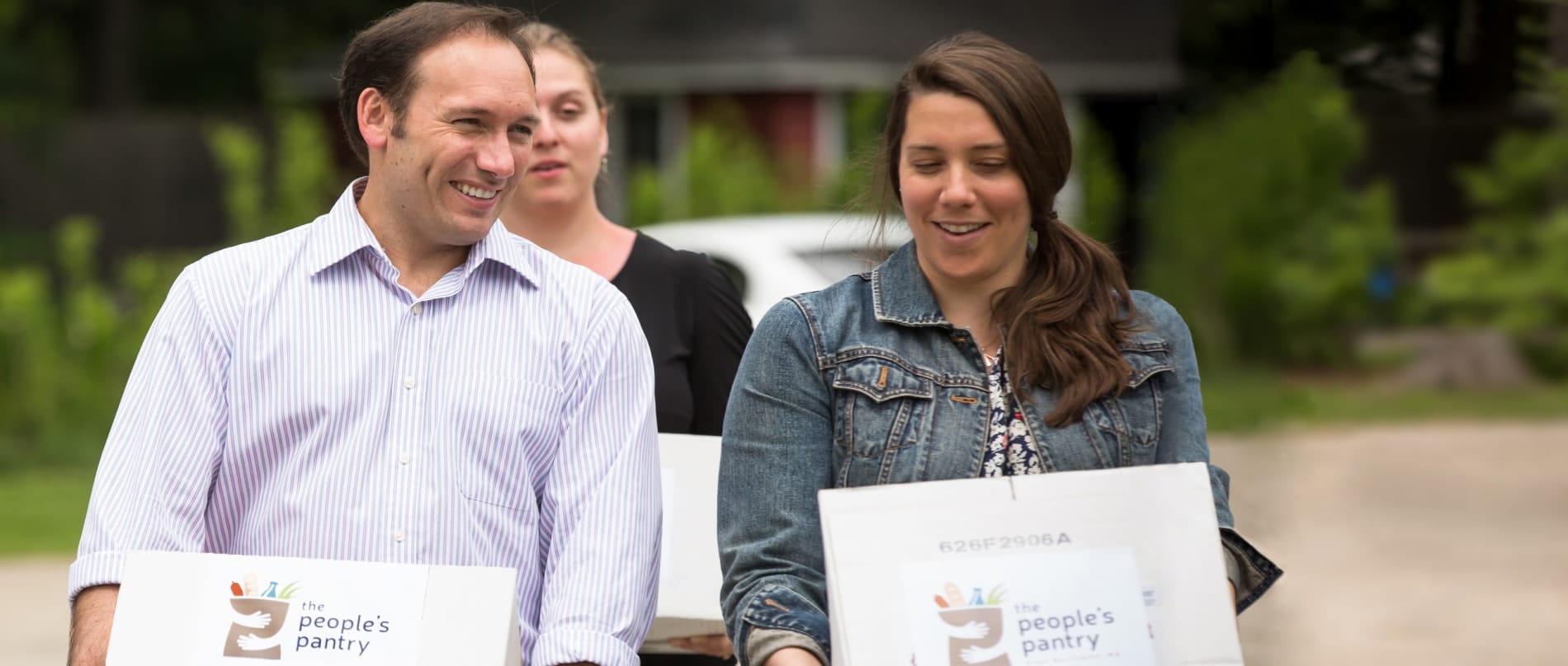 A man and two women carrying food for the homeless to the People's Pantry in Great Barrington, Massachusetts.