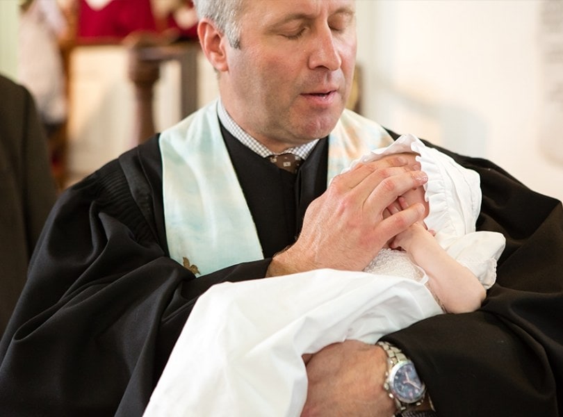 Rev. Brent Damrow baptizes a baby girl