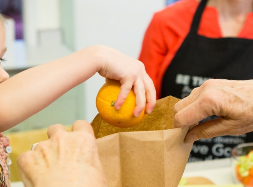 Two children fill bags of food for the hungry and homeless in Pittsfield, Massachusetts