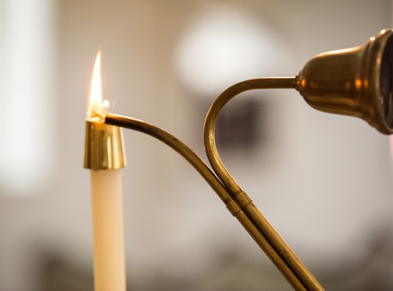 A candle is lit in a church