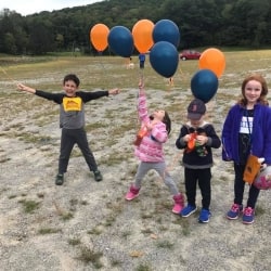 A group of kids holding balloons