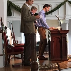 A young man reads from the pulpit
