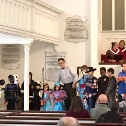 A group of children wearing Halloween costumes in the church sanctuary