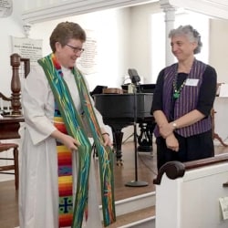 Rev. Patty Fox holds her new clerical stole up before the congregation