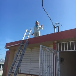 A worker waves from a roof
