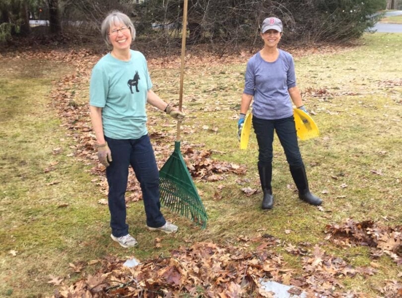 Smiling volunteers with rakes