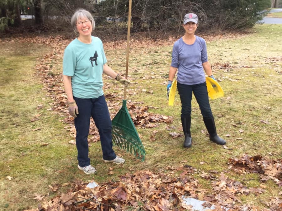 Smiling volunteers with rakes