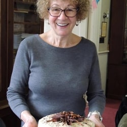 A woman carries a chocolate cake