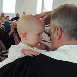 Pastor Brent Damrow baptizes baby Gwendolyn