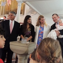 Gwendolyn's parents and godparents smile at the congregation