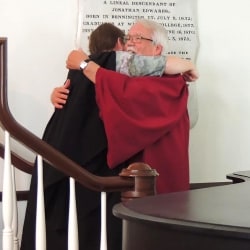 A choir member hugs the departing minister of music