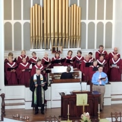 Choir members sing in front of the organ