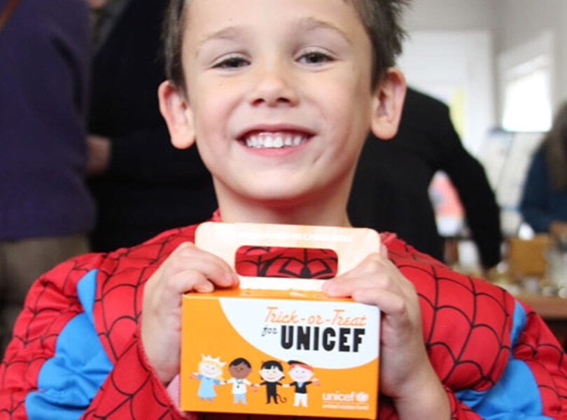 A boy dressed as Spiderman trick-or-treats for UNICEF