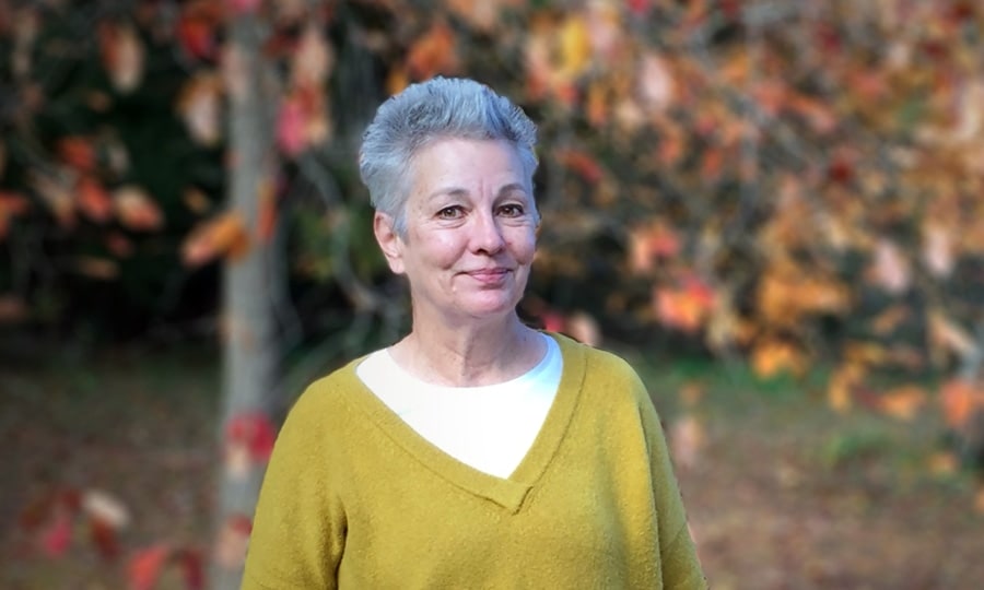 A woman with fall leaves in the background