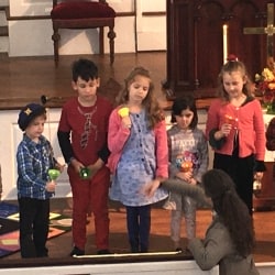 A woman conducts the children's choir