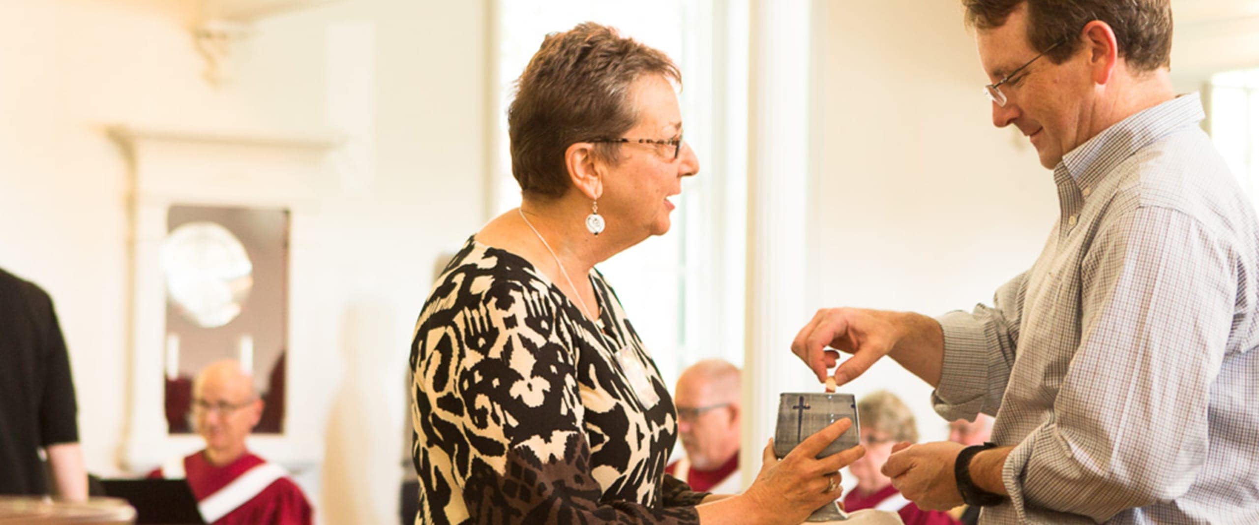 A woman serves communion to a man