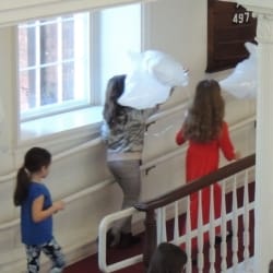 Children parade around the church holding dove-shaped balloons